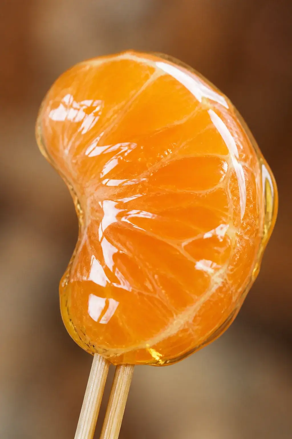 closeup of a single mandarin segment tanghulu on skewers